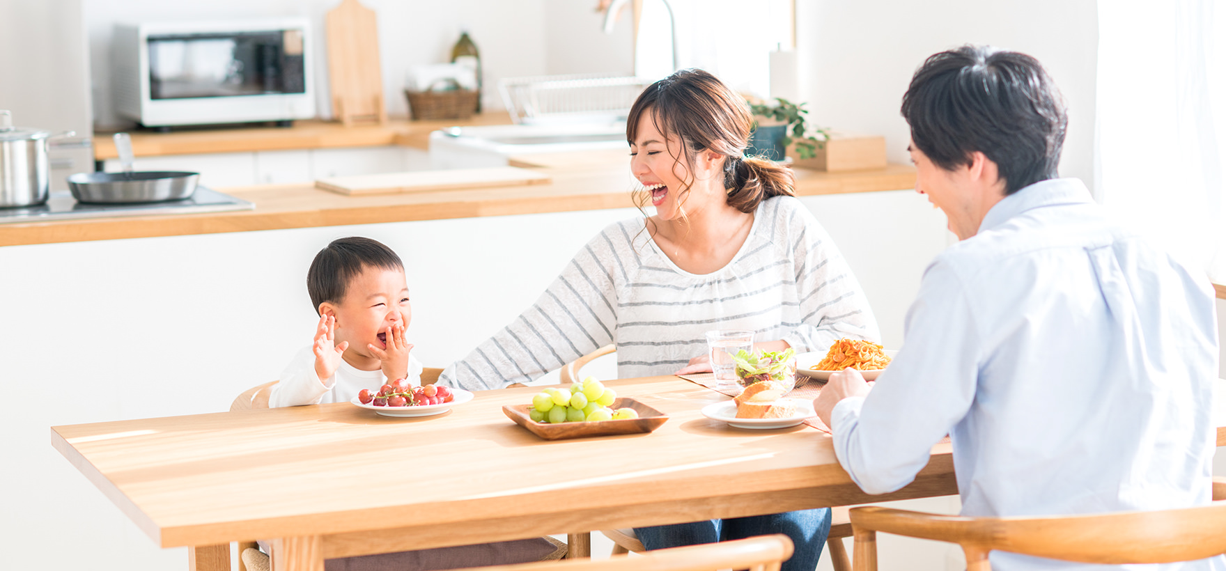 家族が果物を食べて晴ればれ笑顔が溢れる写真