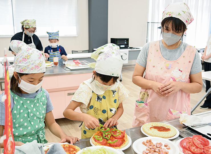 特産の「桃太郎トマト」を使ってピザを作る親子