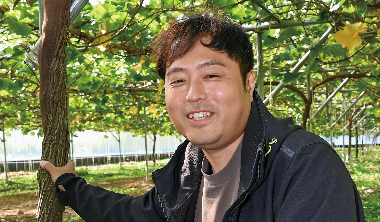 田畑に広がるブドウに思いを馳せる横山さん写真