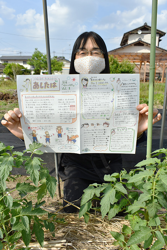 女性部だより「あしたば」を」持つ右遠部長の写真