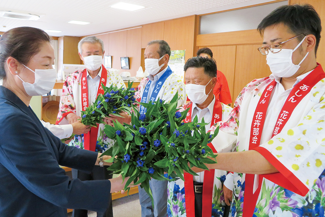 新見市長へリンドウを手渡している奥山部会長の写真