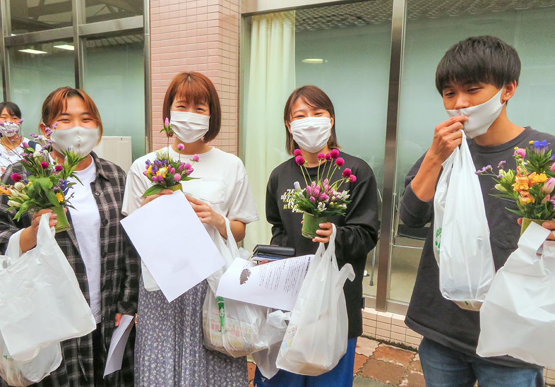 阿新ぶどう部会、田中部会長が学生にエールを贈るの写真
