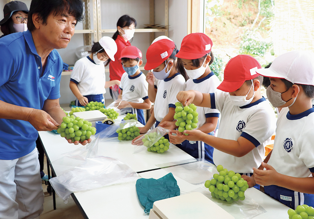 石田さんから荷造りを学ぶ児童の写真