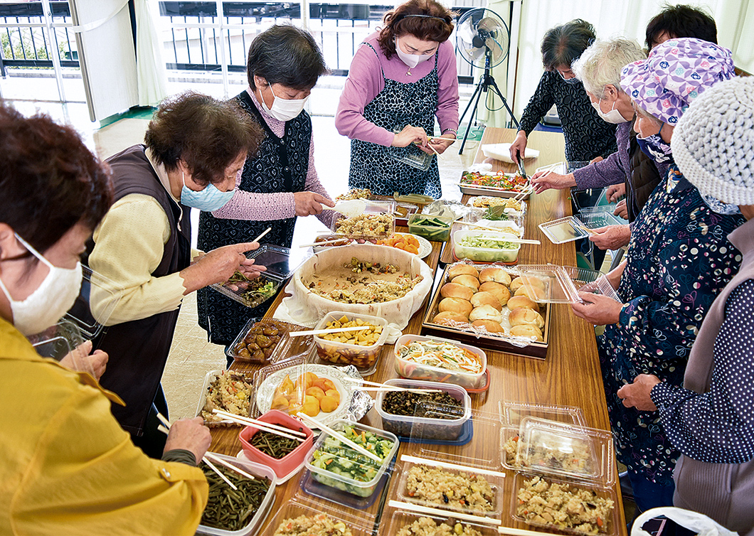 参加者と料理がたくさん並んだの写真