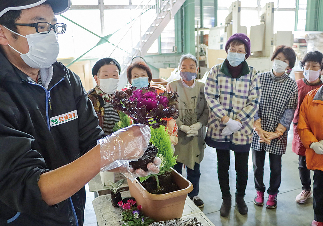 講師（左）から花の特徴を学ぶ部員の写真