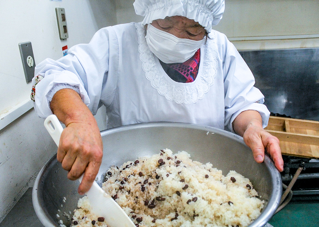 「届けた先にある笑顔が原動力」と赤飯を作る、同地区女性部部長の石部比佐予さんの写真