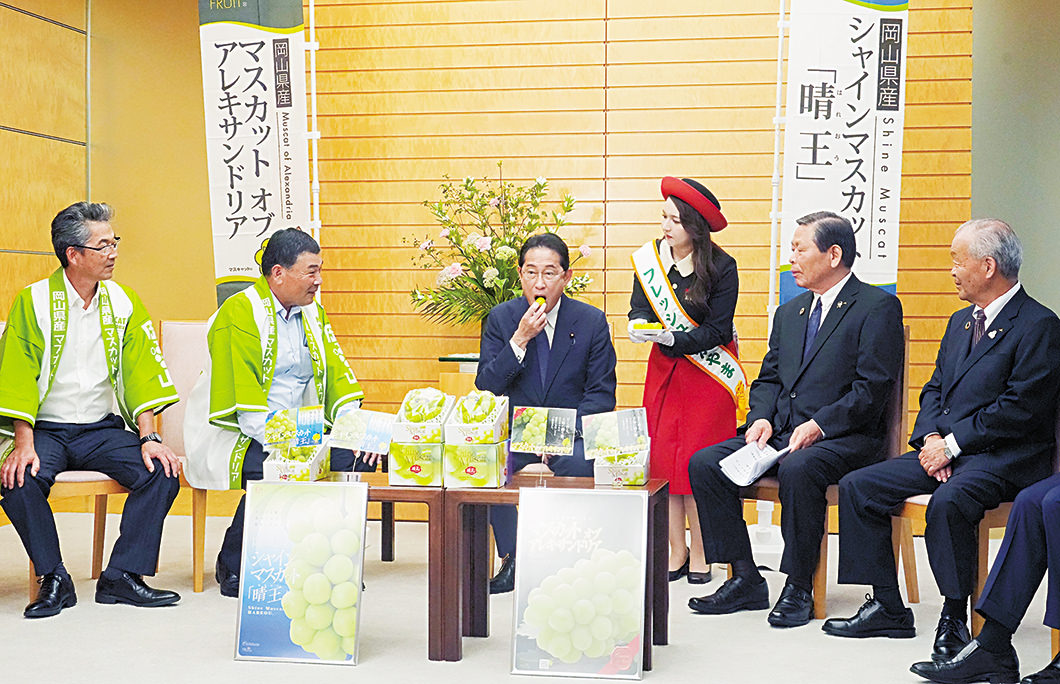 シャインマスカットを口にする岸田首相の写真