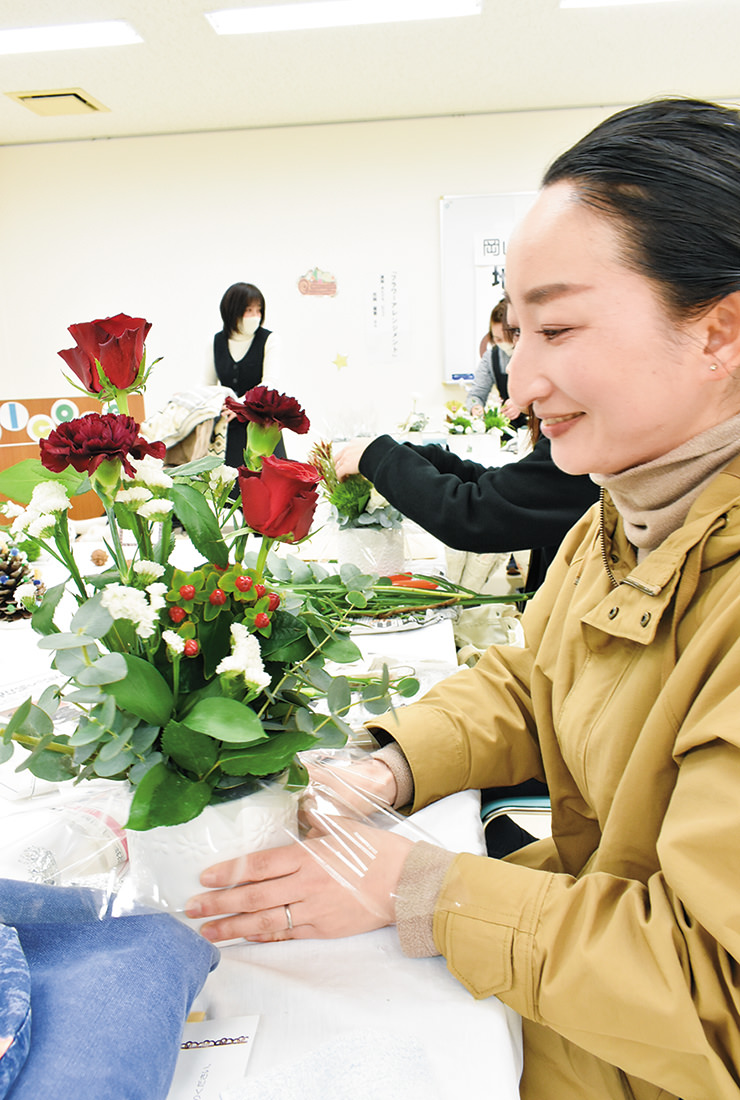 思い思いに花を飾り作品を仕上げる参加者の写真