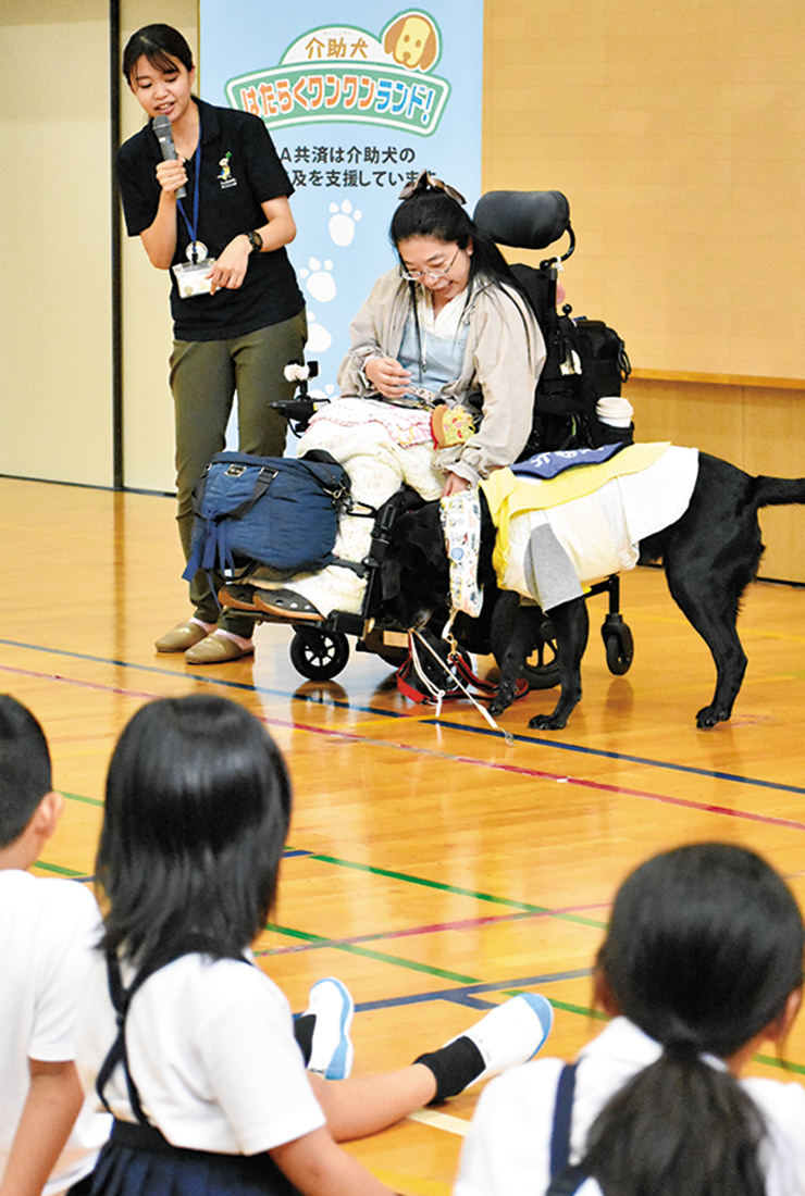 松山さん(上部右)の指示で落としたものを拾う介助犬のサスケの写真