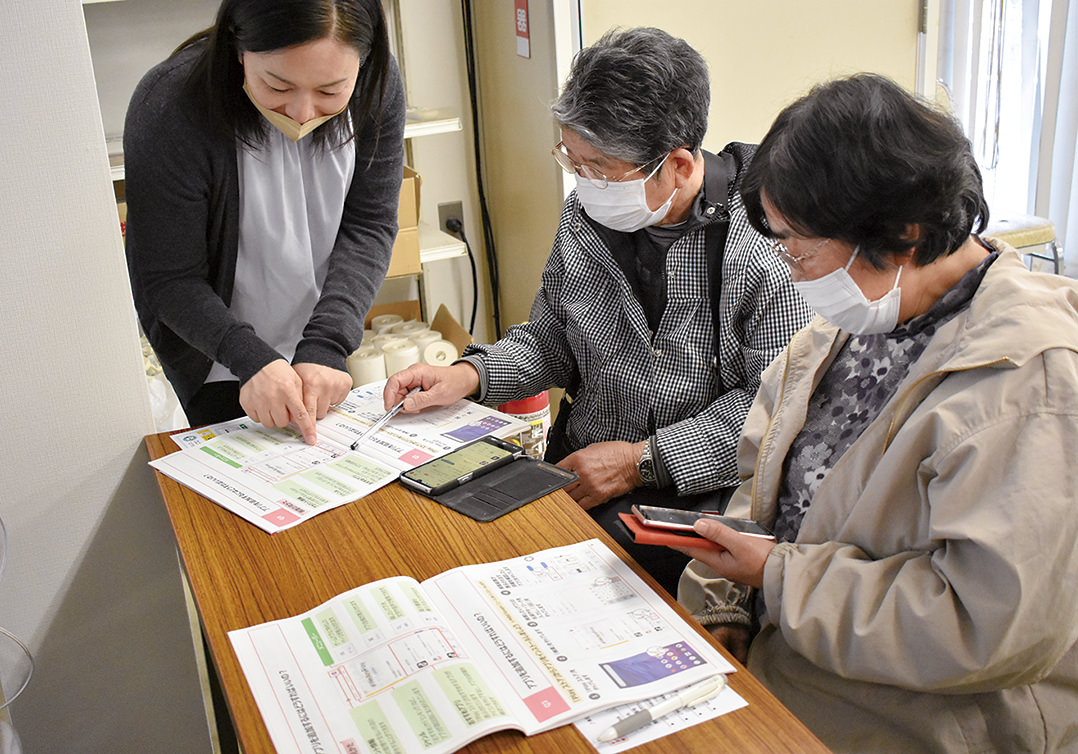 スタッフ（左）に使い方を聞く部員の写真