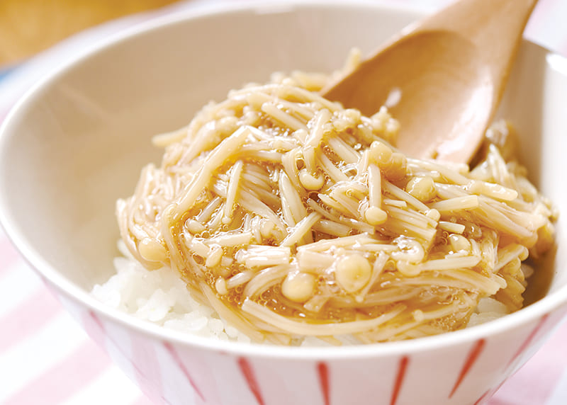 とろみのあるエノキ茸の佃煮をご飯に乗せたおいしそうな写真