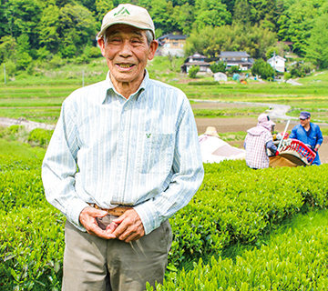 観光客に試食用の「天空の実り」シリーズを渡す藤井部会長（手前）と仲山部会長の写真