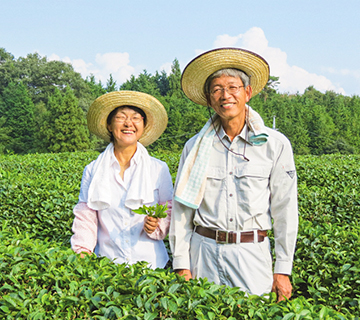 観光客に試食用の「天空の実り」シリーズを渡す藤井部会長（手前）と仲山部会長の写真